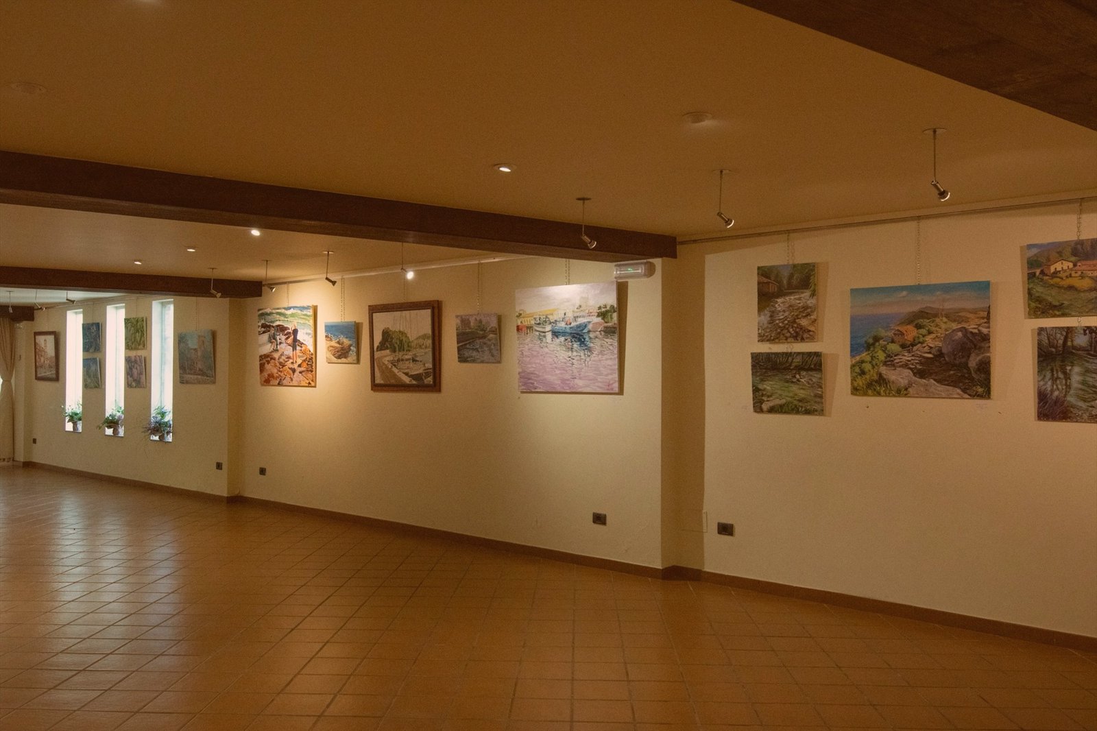 Museum gallery with framed paintings lit by spotlights