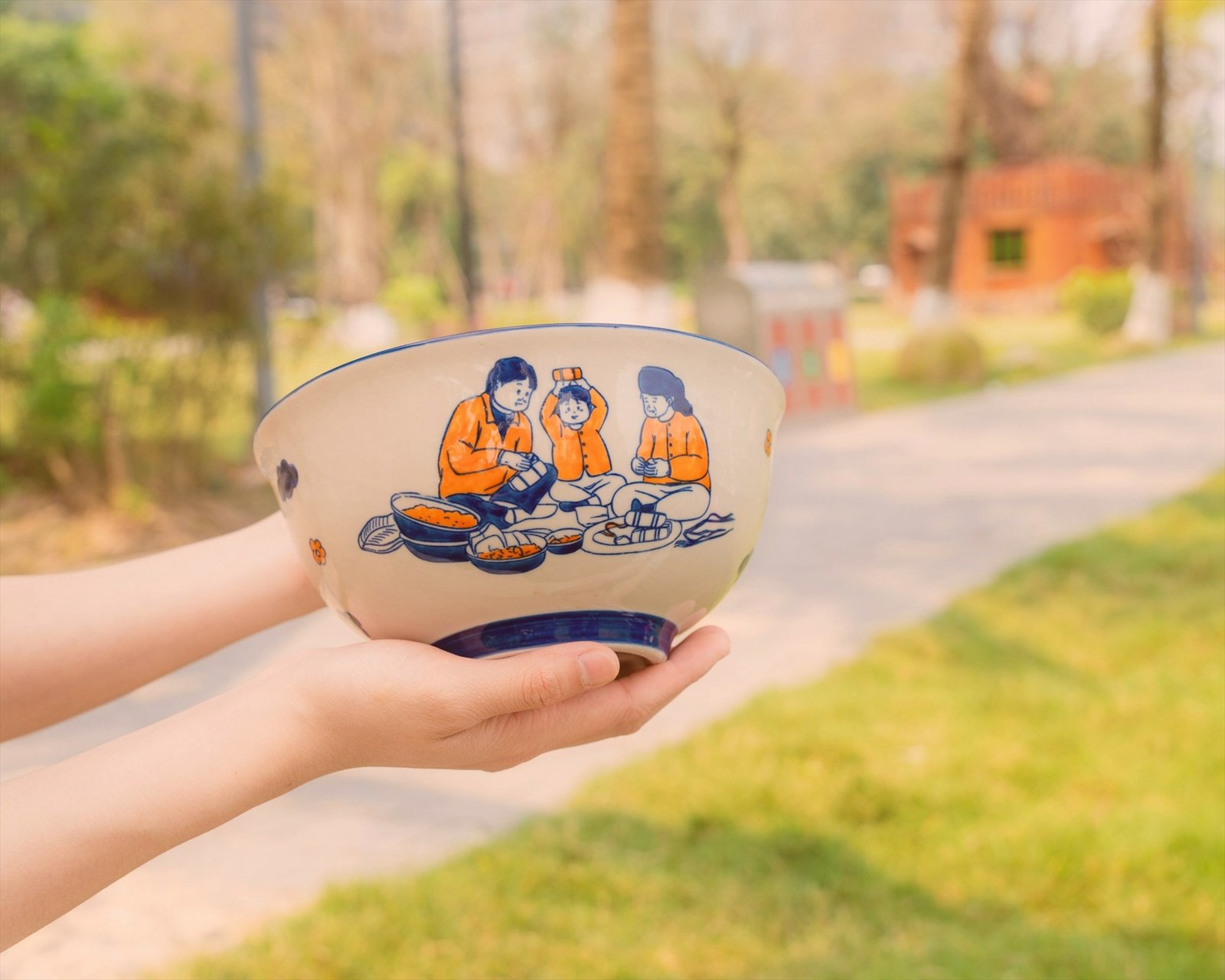 Hands holding a decorated ceramic bowl