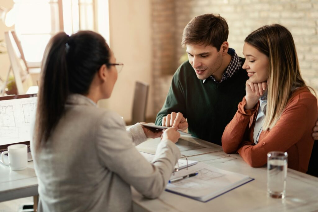 Adviser going over paperwork with a couple at a bright office table